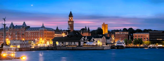 Helsingborgs hamn och stadssiluett i kvällsljus med rådhuset och Kärnan i bakgrunden